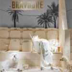Hermès Vitrines d'Été 2024 BRAVOURE - cinema stadium seats with two white fluffy dogs, popcorn bucket, Hermès bag and palm tree backdrop in surreal window display