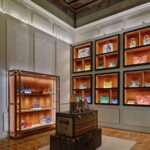 Moynat Opening Milano 2026 – Full interior view of boutique with illuminated terracotta niches, personalised trunks and colourful bag wall display, photographed by Davide Palombo